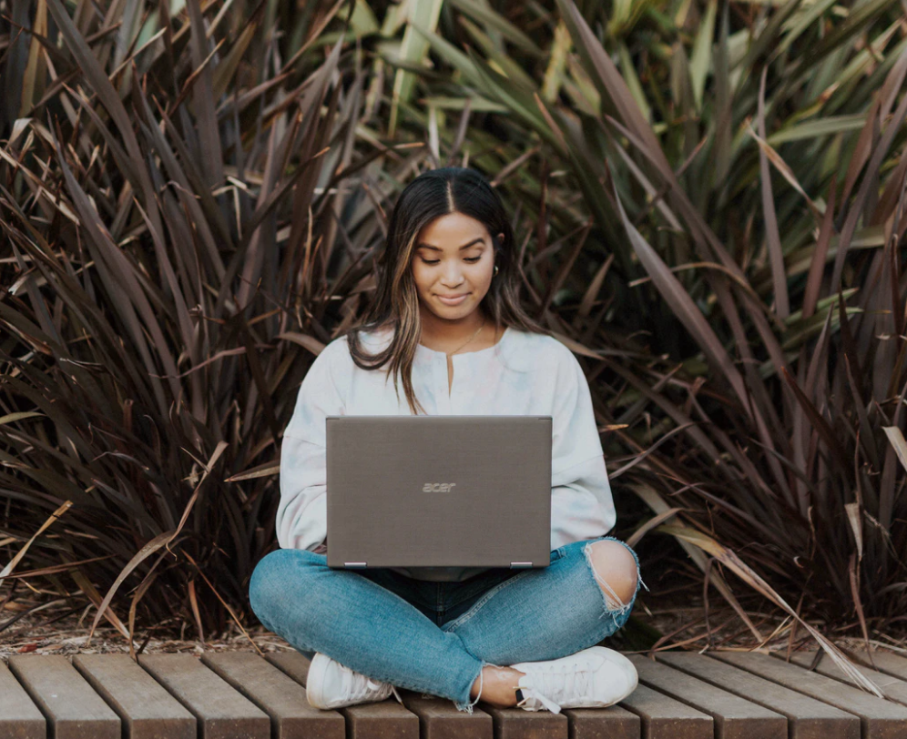 university applications, student sitting cross-legged with laptop