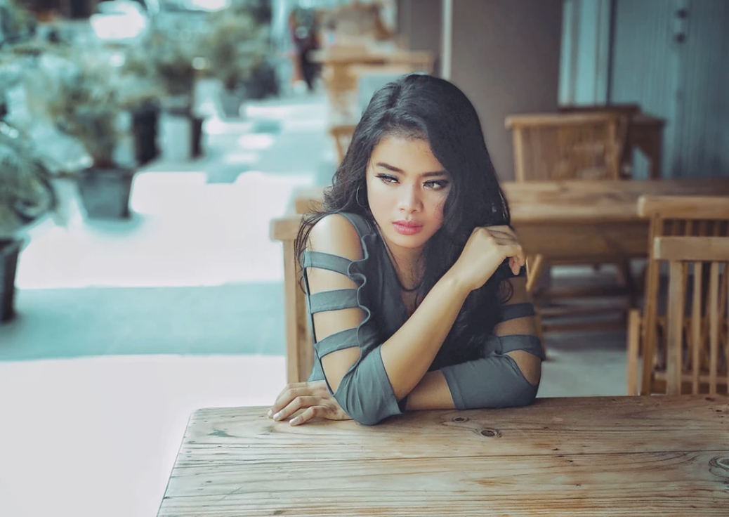 woman in striped shirt leaning on table looking away from camera MBA